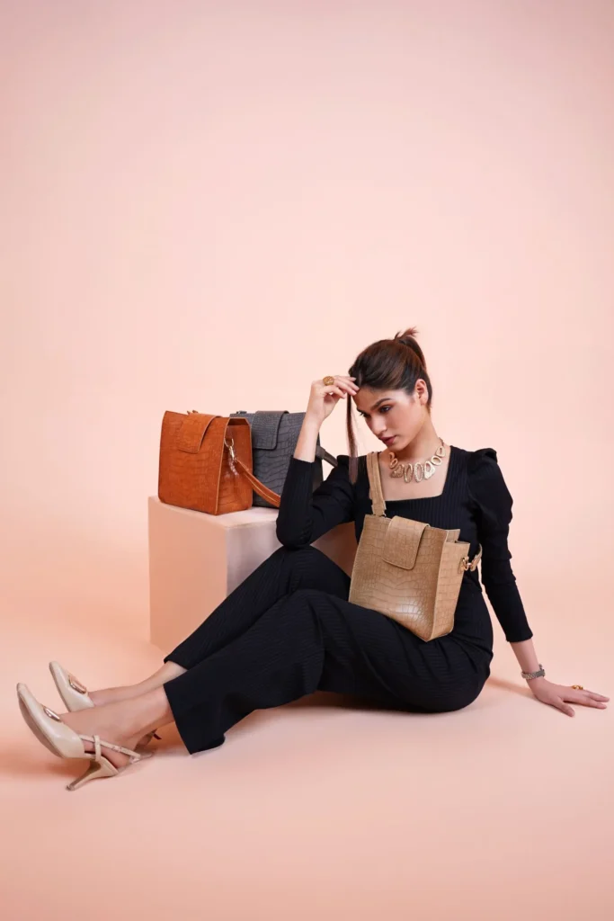 Chic woman showcasing a trendy stylish black outfit with designer handbags in a studio setting. wear Perfect for fashion and style concepts.